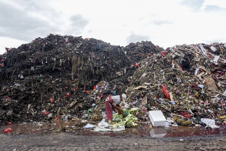 Trash troubles: A scavenger collects items from piles of garbage on Jan.9 at the Kramat Jati Wholesale Market in Jakarta.