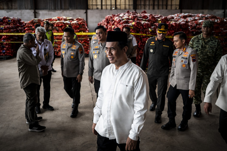 Agriculture Minister Andi Amran Sulaiman (center) leaves the site after inspecting seized illegal onions at a warehouse complex on Jan 10, 2026, in Semarang, Central Java. Authorities confiscated 133.5 tonnes of onions suspected to have been smuggled into the country.