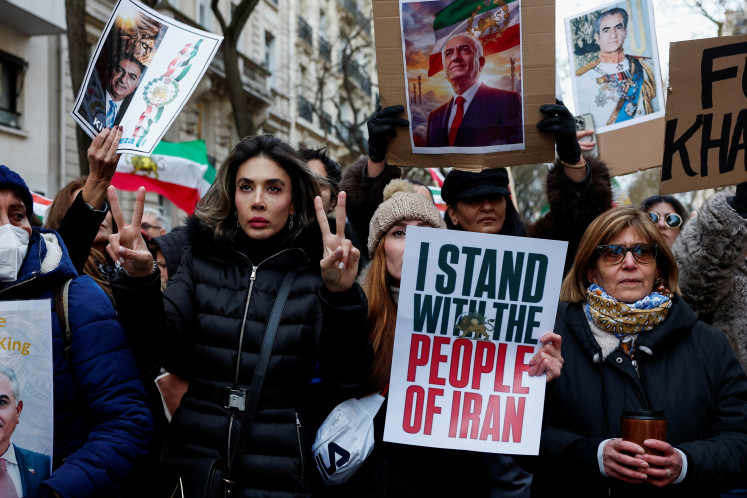 A person holds a picture of Reza Pahlavi, the exiled son of the last Shah of Iran as demonstrators and activists rally in support of nationwide protests in Iran, in Paris, France, January 11, 2026.