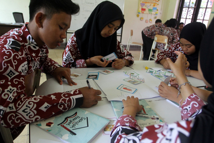 Students take part on Jan. 14, 2026, in a chemistry lesson using flash cards at a Sekolah Rakyat (community school) in Malang, East Java. 