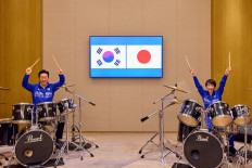 Japanese Prime Minister Sanae Takaichi (right) and South Korean President Lee Jae Myung pose on Jan. 12, 2026, for photographs before performing on drums after their meeting in Nara, Japan. 