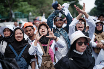 Loud and proud: Demonstrators react as the music pauses during a labor rally calling for better working conditions on Oct. 30, 2025, near the National Monument (Monas) park in Central Jakarta. 
