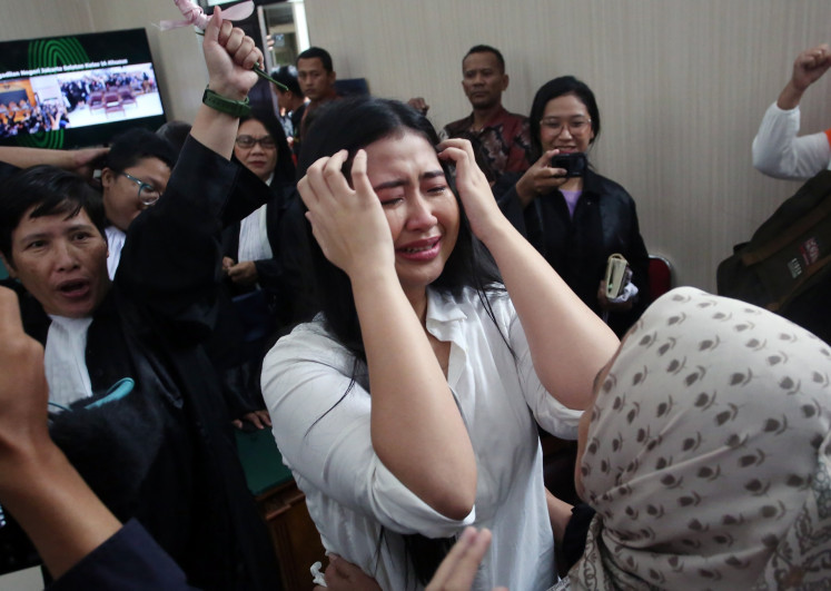 Defendant Laras Faizati Khairunnisa (center) cries after a verdict hearing against her on Jan. 15 at the South Jakarta District Court in Jakarta. Judges found Laras guilty of inciting mass violence through her social media post during the nationwide unrest in August 2025, but ordered her to walk free from prison.