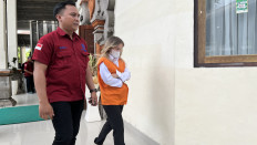 Ukrainian defendant Kateryna Vakarova (right) is escorted by an official from the Bali Prosecutor's Office into the courtroom at Denpasar District Court in Denpasar on Jan. 13, 2026.