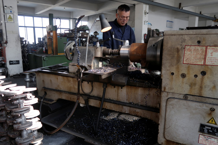 An employee works on the production line manufacturing pipe-fitting valves at a factory in Wenzhou, Zhejiang province, China, on Jan. 14, 2026.