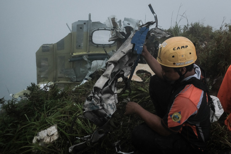 A search and rescue official carries the wreckage of a turboprop aircraft operated by charter airline PT Indonesia Air Transport, a day after it crashed while en route from Yogyakarta to Makassar, on Mount Bulusaraung in South Sulawesi on Jan. 18, 2026.