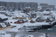 Frozen gambit: A man walks a dog in this aerial photo from Jan. 18, 2026 of Nuuk&rsquo;s old harbor in Greenland. In escalated efforts to acquire Greenland, United States President Donald Trump had threatened tariffs of up to 25 percent on several European countries.
