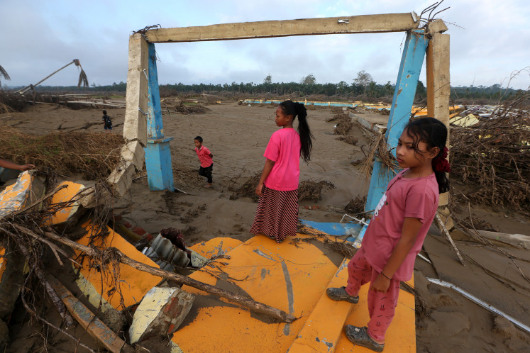 Children stand atop rubble and debris on Jan. 14, 2026, at the former site of Ranto Panyang Rubek elementary school in Pante Bidari, East Aceh, Aceh, which was destroyed during the disaster that struck northern Sumatra on Nov. 26, 2025.