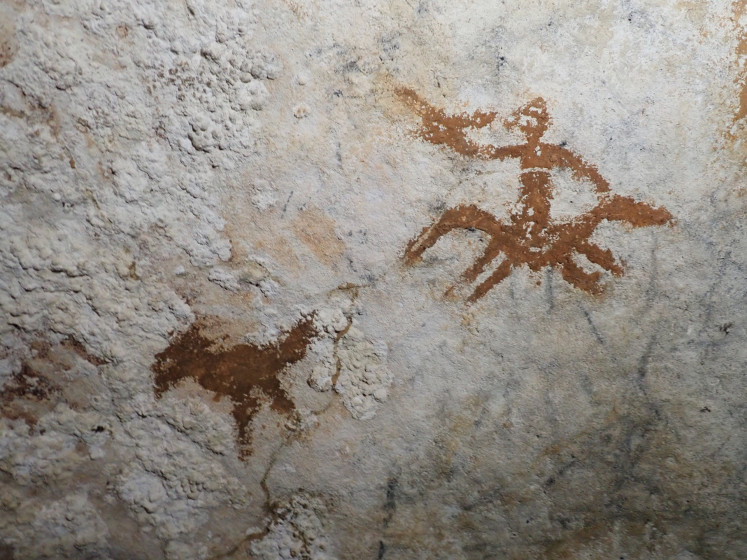 A faded hand stencil, located between the painting of a human riding a horse and a chicken, dated at least 67,800 years old at the Liang Metanduno cave on Muna Island, Southeast Sulawesi is seen in this photo taken in May 2019.