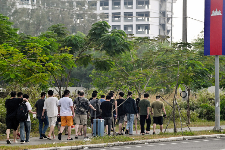 Workers walk out on Jan. 15, 2026, from a suspected scam center in Sihanoukville, Cambodia.