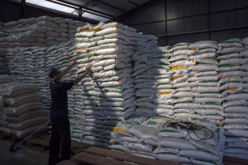 A worker tidies up a stack of locally produced rice on May 30, 2024, at state food company Perum Bulog&rsquo;s warehouse in Indramayu, West Java. 