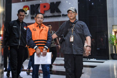 Graft suspect and Pati Regent Sudewo (center) is escorted by Corruption Eradication Commission (KPK) staff on Jan. 20, 2026, after a questioning session at the KPK headquarters in Jakarta.