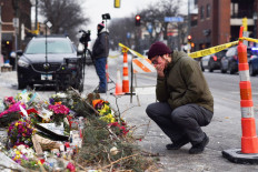 A mourner visits a makeshift memorial in the area where Alex Pretti was shot dead a day earlier by federal immigration agents in Minneapolis, Minnesota, US, on January 25, 2026. On January 24, federal agents shot dead US citizen Alex Pretti, a 37-year-old ICU nurse, while scuffling with him on an icy roadway, less than three weeks after an immigration officer shot and killed Renee Good, also 37, in her car.