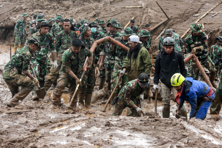 Rescuers search for victims buried by a landslide in Pasirlangu village in Bandung, West Java, on January 26, 2026. 