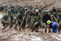 Rescuers search for victims buried by a landslide in Pasirlangu village in Bandung, West Java, on January 26, 2026. 