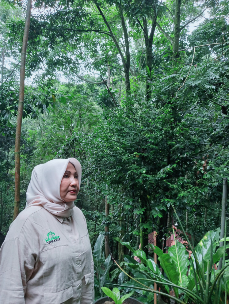Rosita Istiawan, 64, stands in the forest she and her family nurtured on Jan. 12 in Megamendung district, Bogor regency, West Java. Purchased as barren land in 2001, the plot was transformed into a lush forest now home to around 44,000 trees.