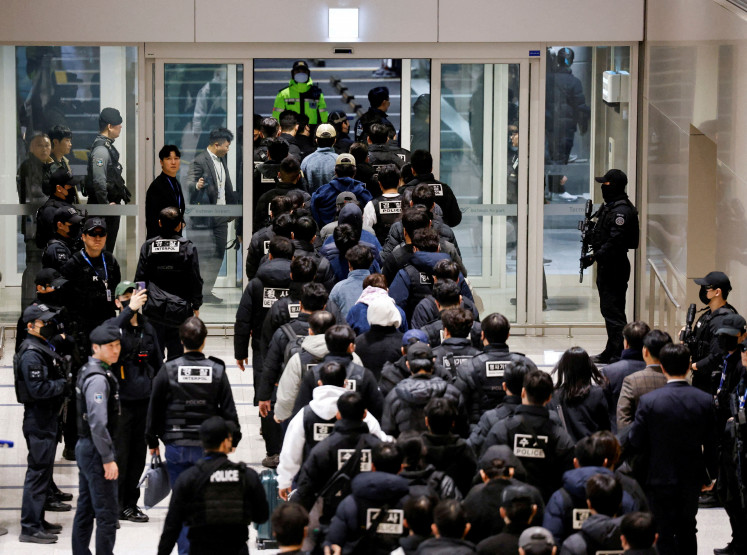 Police officers escort South Koreans allegedly involved in scam operations in Cambodia after being forcibly repatriated from Cambodia, at Incheon International Airport in Incheon, South Korea January 23, 2026.
