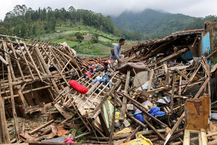 Ahmad Rohimat, 30, collects belongings from his damaged house following a landslide due to heavy rains in Pasir Langu village, West Bandung regency, West Java province, Indonesia, January 27, 2026.