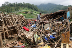 Ahmad Rohimat, 30, collects belongings from his damaged house following a landslide due to heavy rains in Pasir Langu village, West Bandung regency, West Java province, Indonesia, January 27, 2026.