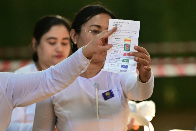 Members of Myanmar's Union Election Commission (UEC) count ballots on Jan. 25 at a polling station in Yangon after the closing of polls in the third phase of Myanmar's general election.