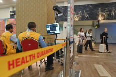 Denpasar Health Quarantine Agency officials check the monitor of a thermal scanner on Jan. 29 at I Gusti Ngurah Rai International Airport in Bali. Indonesia tightened screening at several airports after two Nipah virus cases were reported in India.