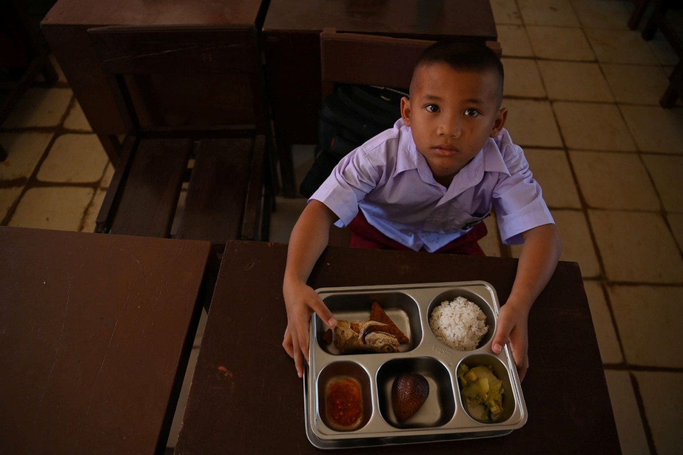 Lunch break: A student shows his free nutritious meal on Jan. 28, 2026 at SDN 18 state elementary school in Tukka, Central Tapanuli regency, North Sumatra. The program has resumed after floods hit the regency in November last year.