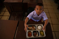 Lunch break: A student shows his free nutritious meal on Jan. 28, 2026 at SDN 18 state elementary school in Tukka, Central Tapanuli regency, North Sumatra. The program has resumed after floods hit the regency in November last year.