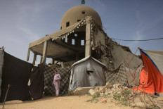 A child stands next to the al-Albani Mosque on Jan. 30, 2026, which was destroyed during Israeli military strikes, in Khan Yunis, southern Gaza Strip. Israel's military denied on Jan. 30 having accepted the Palestinian health ministry's death toll for the war in Gaza of 71,000 killed since October 2023, as was reported in Israeli media. 