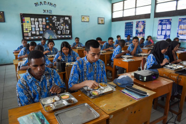 Students eat meals provided under the free nutritious meal program at SMAN 1 Wamena senior high school in Jayawijaya regency, on Jan. 14, 2026, when Vice President Gibran Rakabuming Raka inspected program rollout in Wamena district, Highland Papua.