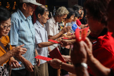 Everyone wins: Elderly residents receive cash-filled red envelopes from Tay Kak Sie Chinese Temple Foundation officials on Feb. 1 during an event to distribute angpao at the grand temple in Semarang, Central Java. The tradition also includes the distribution of basic food staples for about 1,500 elderly people and underprivileged residents as an expression of social care ahead of the Lunar New Year.