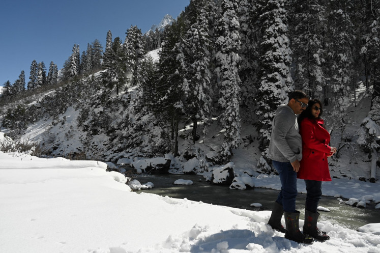 Tourists walk in a snow-covered park on Feb. 28, 2021, at Gagangeer, some 70 kilometers northeast of Srinagar, Jammu, India.