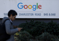 A pedestrian walks by a sign at Google headquarters on Feb. 4, 2026, in Mountain View, California, United States. Google parent company Alphabet reported better-than-expected fourth-quarter results, with revenue rising 18 percent from a year earlier.