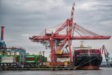 Workers load and unload containers at the Tanjung Priok International Export-Import Port in Jakarta on February 4, 2026. 