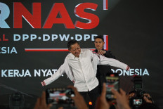 Indonesian Solidarity Party (PSI) chair Kaesang Pangarep (right) puts a party jacket on former Nasdem Party politician Rusdi Masse (left) on Jan. 29 during the opening of the PSI's national working meeting in Makassar, South Sulawesi.