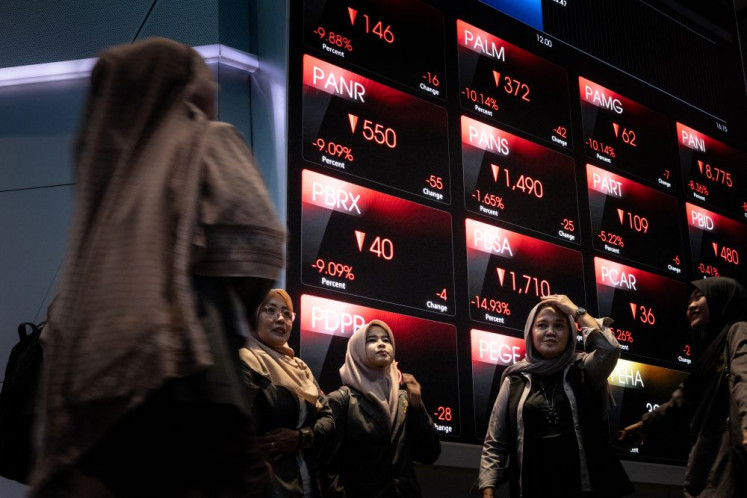 Momentous shot: A group of visitors takes a picture on Jan. 29, 2026 in front of a stock ticker display at the Indonesia Stock Exchange (IDX) in South Jakarta.