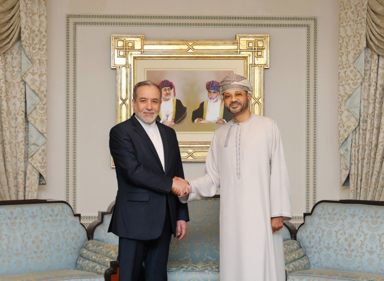 This handout photo from by Omani Ministry of Foreign Affairs released on February 6, 2026, shows Iranian Foreign Minister Abbas Araghchi (left), shaking hands with Oman Foreign Minister Badr bin Hamad al-Busaidi, in Muscat on February 6, 2026. 