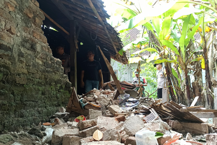 Police and military personnel inspect buildings damaged by the earthquake on Feb. 6, 2026, in Suruh Village, Trenggalek Regency, East Java. Authorities reported that seven homes and one village office in the regency were damaged after a 6.4-magnitude earthquake struck the area at around 1 a.m.