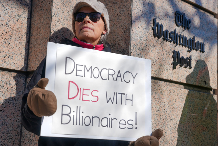 A woman holds a placard as union members and supporters gather at a 'Save the Post' rally outside 'The Washington Post' office after widespread layoffs were announced in Washington, D.C., the United States on Feb. 5, 2026.