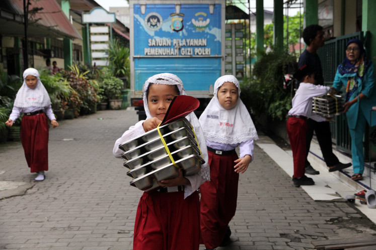 Pupils carry food dispersed by the free nutritious meal program on Feb. 4, 2026, at state Islamic elementary school Madrasah Ibtidaiyah Negeri Medan in North Sumatra. 