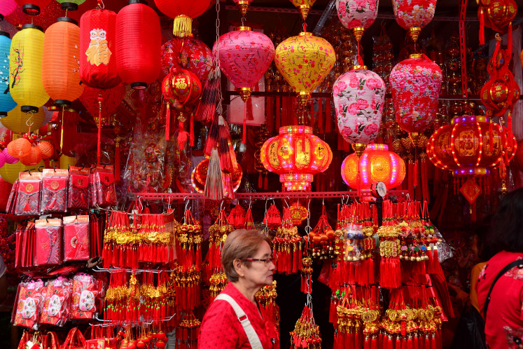 A woman walks past Lunar New Year decorations on Feb. 8, 2026 in the Petak Sembilan area of Glodok, West Jakarta. About a week ahead of the Lunar New Year, ethnic Chinese residents begin shopping for festive ornaments to mark the Year 2577 on the Chinese calendar.