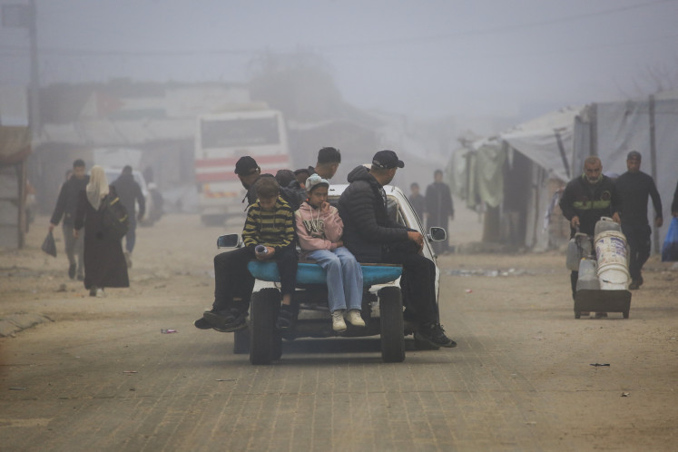 Palestinians ride on the back of a car-pulled cart in Khan Yunis, in the southern Gaza Strip, on Feb. 10, 2026. A United States-brokered ceasefire, which sought to halt the fighting between Israel and Hamas sparked by the group's October 2023 attack, took effect last October, reducing the level of bombing and fighting.