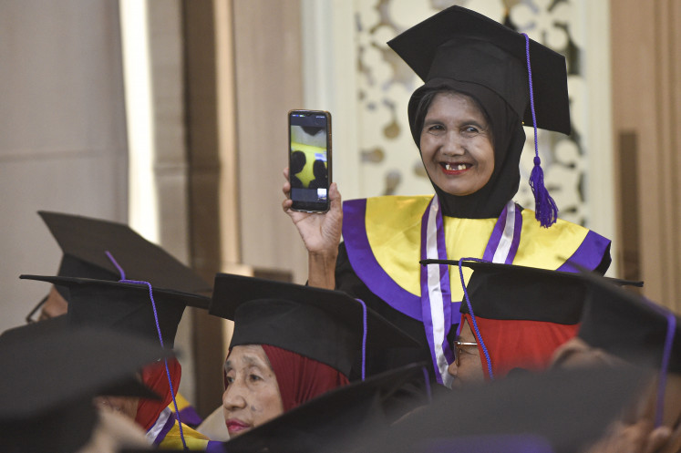 An elderly student at Jambi city&rsquo;s Senior School makes a phone call on Feb. 10, 2026, during a graduation ceremony at the Griya Mayang Hall, the official residence of the Jambi mayor, in Jambi. The Jambi city administration inaugurated 158 elderly participants from the Paal Merah, Kota Baru and Danau Sipin districts after they completed their education.