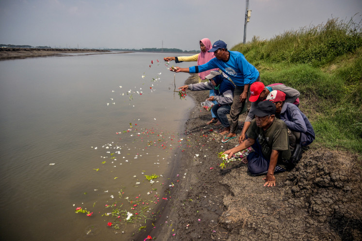 River prayers: Victims of the Lapindo mud volcano tragedy lay flowers on a riverbank on May 29, 2025, to mark the 19th anniversary of the natural disaster in Porong, Sidoarjo regency, East Java.