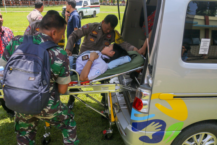 Members of the Indonesian military (TNI) and police evacuate students on Jan. 29, 2026 that are suspected to have suffered from food poisoning from the free meals program at a senior high school in Kudus regency, Central Java. 