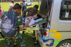 Members of the Indonesian military (TNI) and police evacuate students on Jan. 29, 2026 that are suspected to have suffered from food poisoning from the free meals program at a senior high school in Kudus regency, Central Java. 