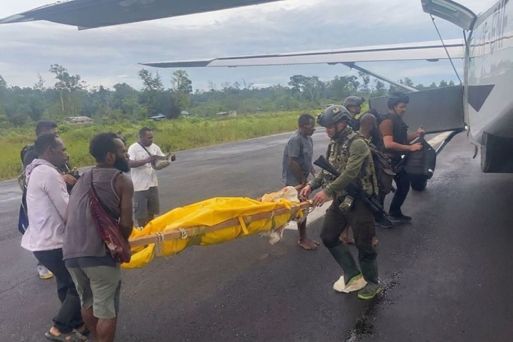 Ongoing conflict: Personnel from a joint military and police team remove the bodies on Feb. 12 of a Smart Air pilot and copilot at Korowai airfield in Boven Digoel regency, South Papua.