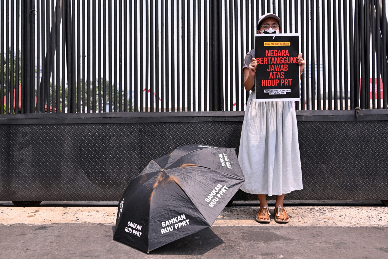 An activist takes part in a hunger strike outside the Senayan Legislative Complex in Central Jakarta on Aug. 14, 2023, as part of a protest demanding lawmakers pass the long-awaited domestic workers protection bill.