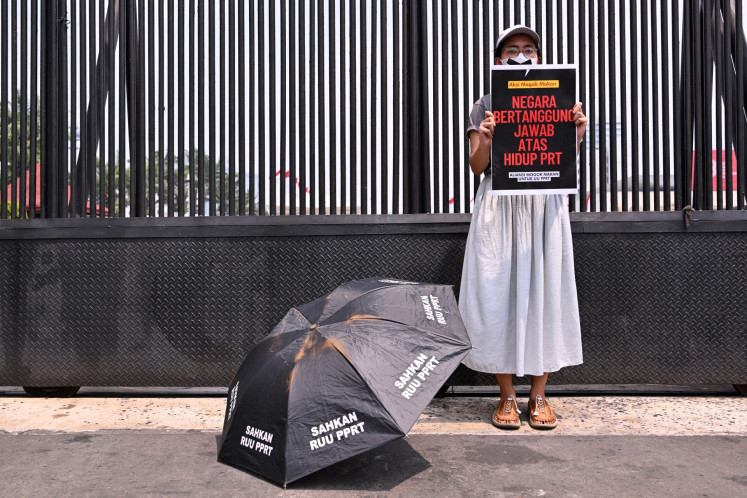 An activist takes part in a hunger strike outside the Senayan Legislative Complex in Central Jakarta on Aug. 14, 2023, as part of a protest demanding lawmakers pass the long-awaited domestic workers protection bill.