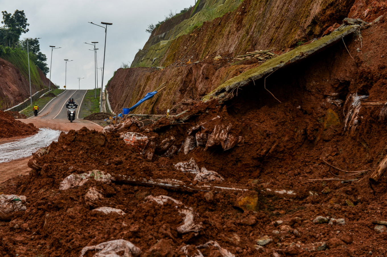 A motorist passes a section of the North Jatigede Ring Road on Feb. 13, 2026, that was hit by a landslide, in Sumedang, West Java. The landslide, triggered by heavy rain that hit Sumedang in February, caused the temporary closure of the route connecting Sumedang and Majalengka regencies.