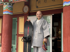 Venerable Hosan, head monk of Bongsunsa Temple, poses for a photo with his snowboard during an interview at the temple in Namyangju, South Korea on Feb. 12, 2026. A Buddhist monk has drawn international attention after South Korea won landmark Olympic snowboard medals in Italy, capping more than two decades of his support for young athletes in a sport long unpopular at home.